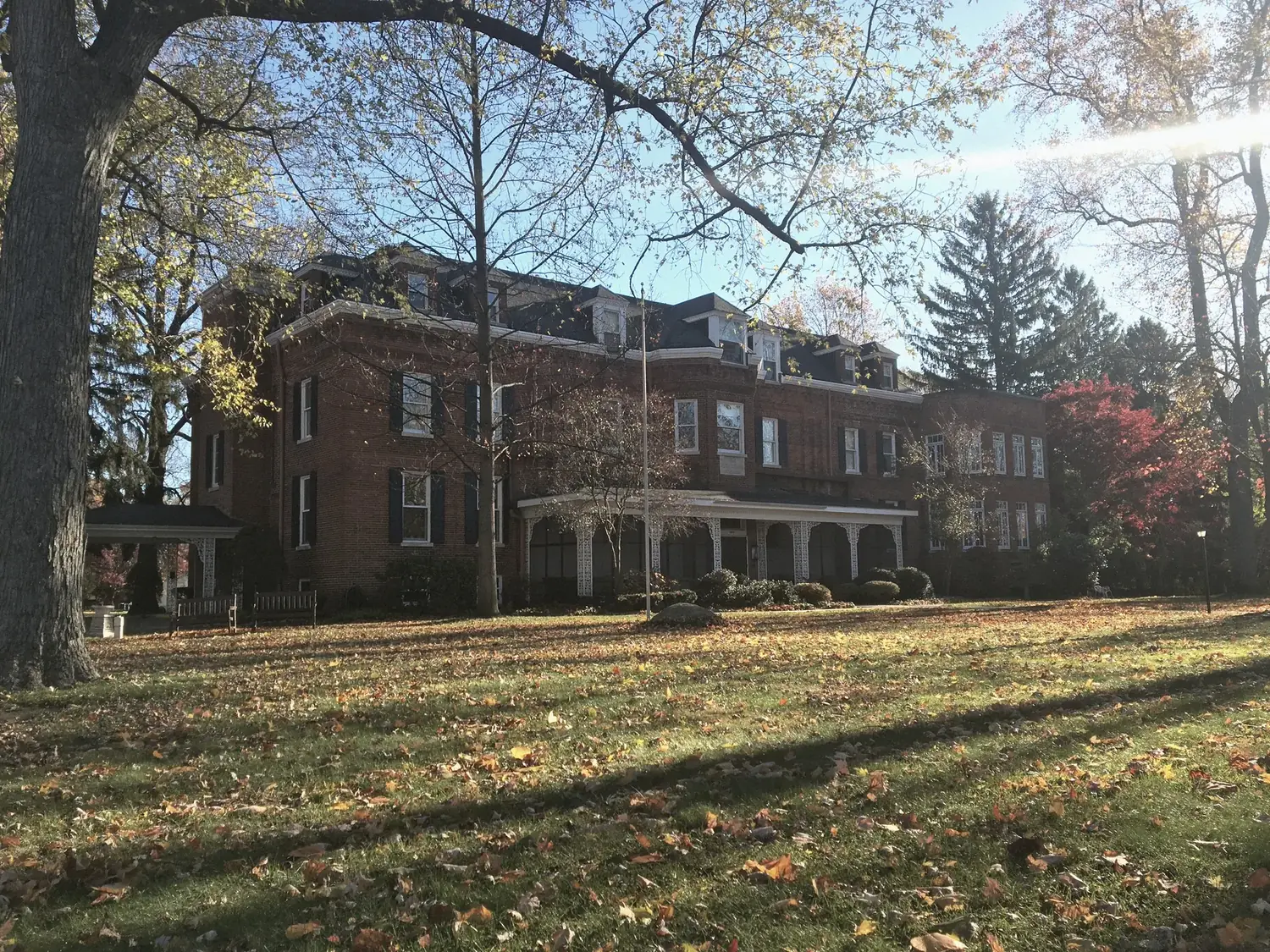 Autumn exterior of The Old Ruth executive housing — golden lawn and low sun on the 3.3-acre grounds