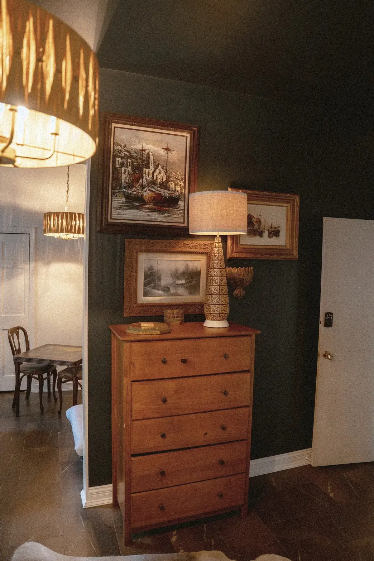 Dark-walled bedroom vignette with artwork and dresser at The Old Ruth
