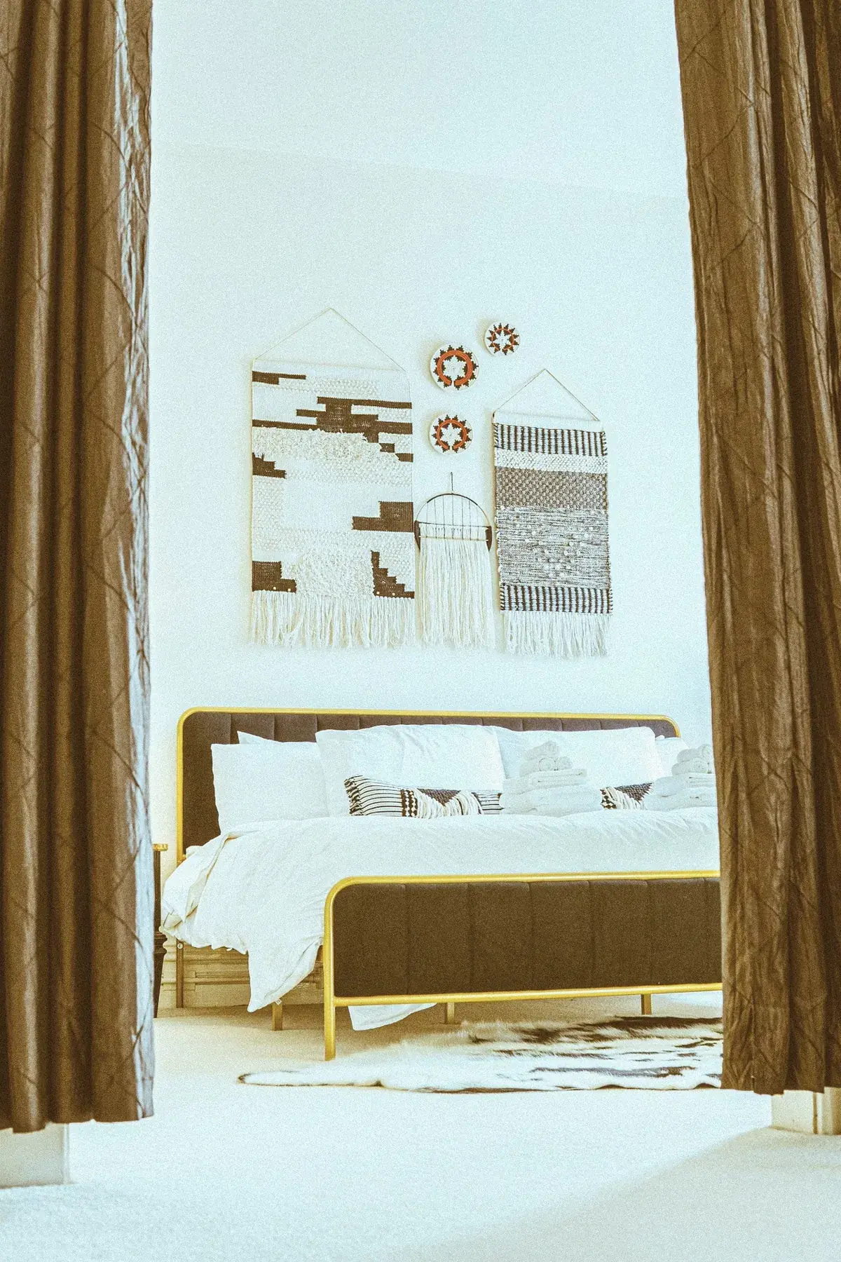 Modern bed framed by drapery in a furnished suite at The Old Ruth