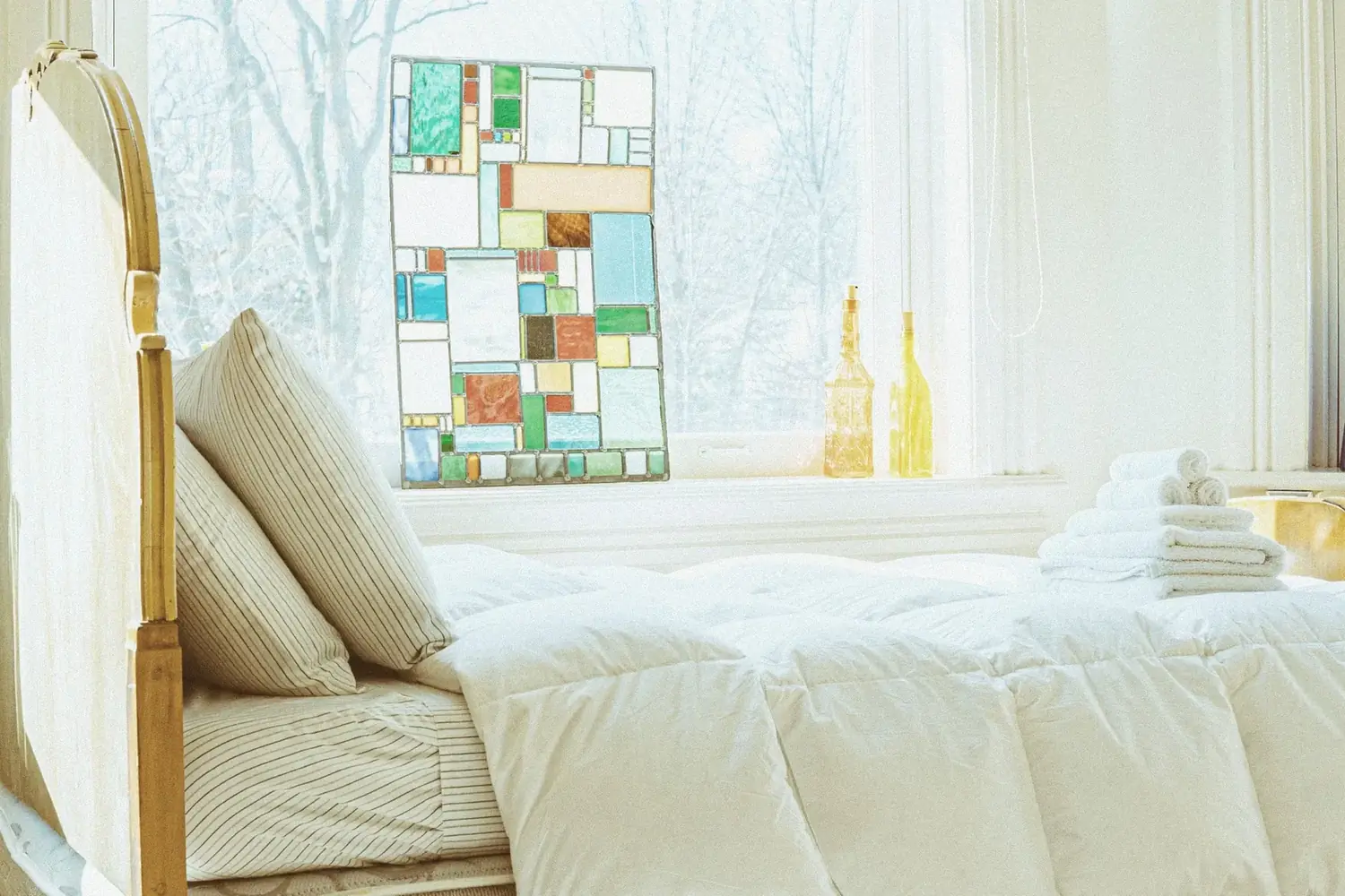Bright bedroom beside a stained-glass panel window at The Old Ruth, La Porte, Indiana