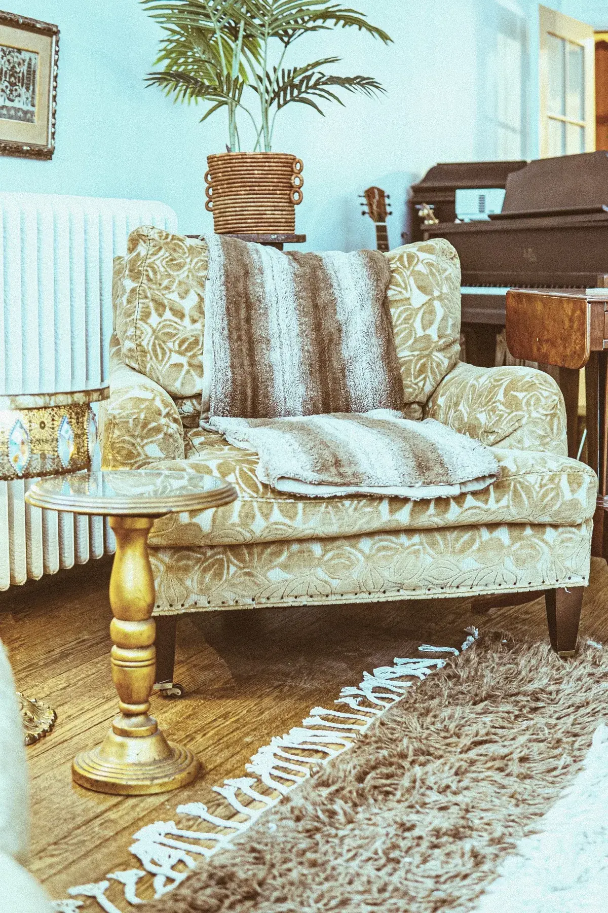 Piano corner at The Old Ruth with cozy chair, throw, and layered textures