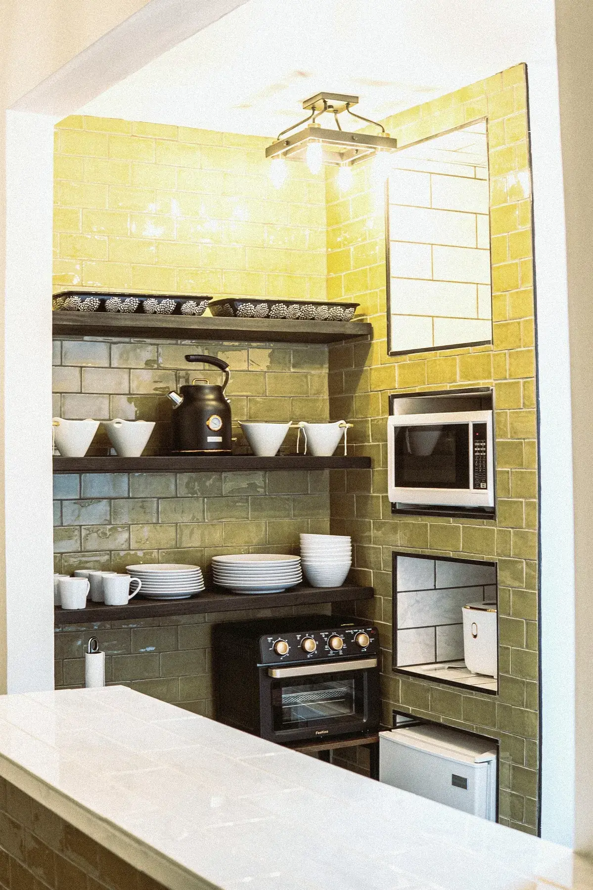 Green and gold tile kitchenette at The Old Ruth — extended-stay corporate housing in La Porte