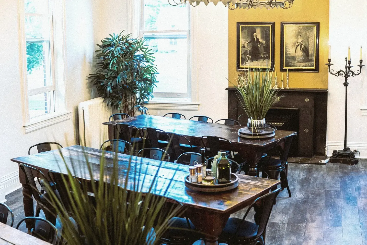 The Table — formal dining room at The Old Ruth with two long tables set beneath portraits and fireplace