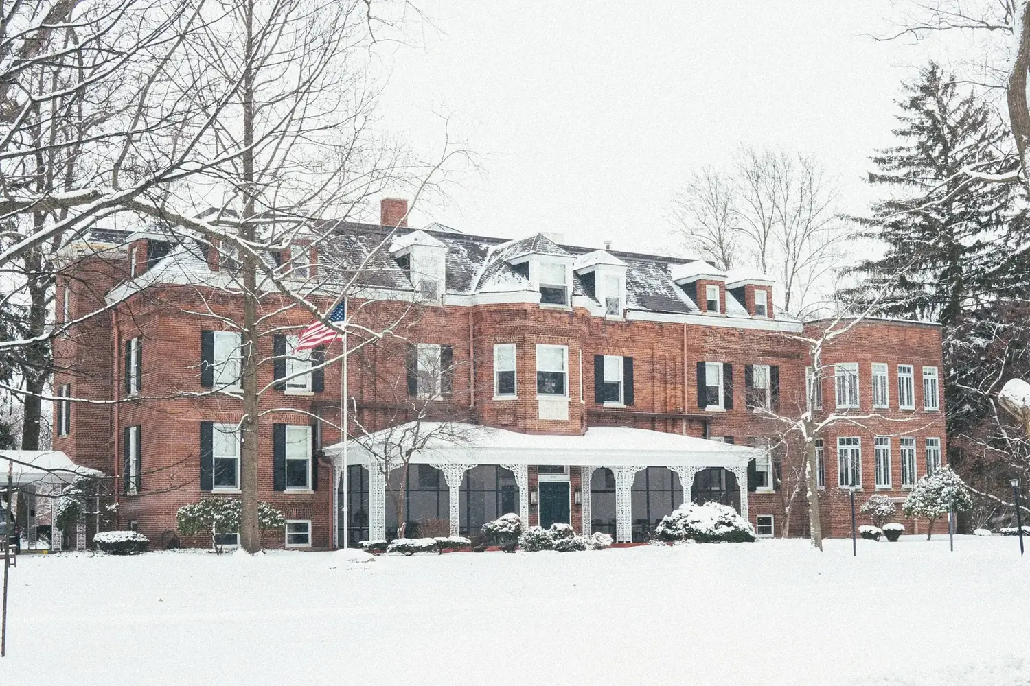 The Old Ruth mansion in winter — circa-1888 brick facade with American flag and snow-covered grounds, La Porte, Indiana